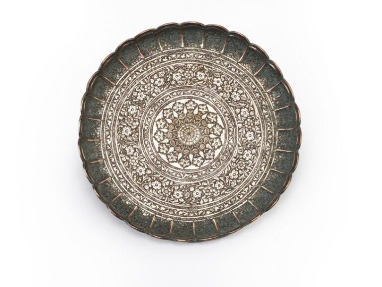 Assiette persane Cuivre étamé Iran, XIXe siècle, Epoque Qadjar Diamètre: 25 cm Cette assiette polylobée est ornée de bandes concentriques à motifs de fleurs et de rinceaux feuillagé