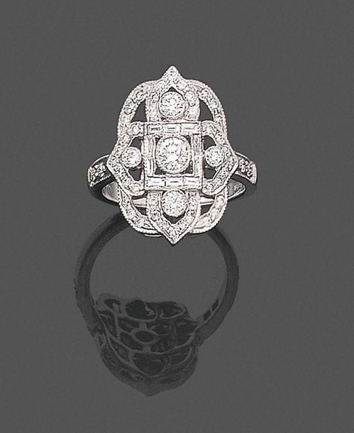 •BAGUE «arabesque» en or gris (750‰) ajouré serti de diamants taille brillant dont trois plus important