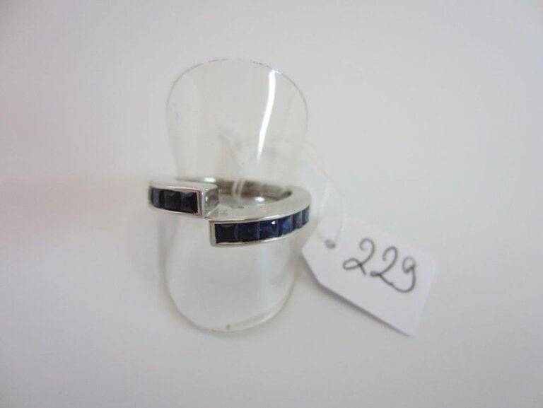BAGUE asymétrique en or gris (750 millièmes) serti de deux alignements de saphirs calibré