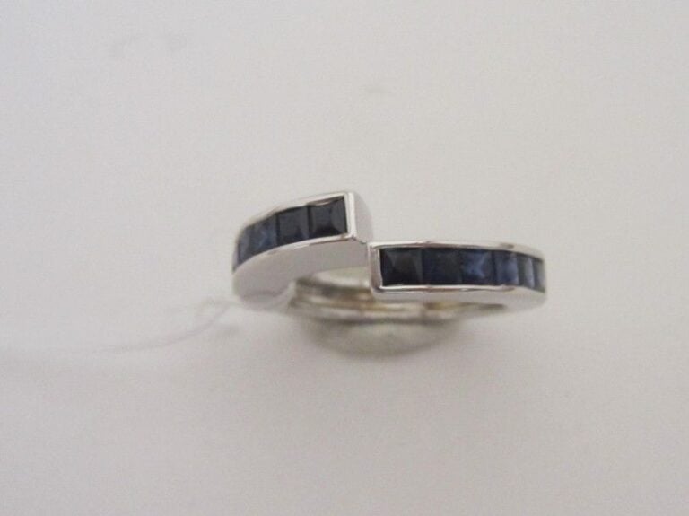 BAGUE asymétrique en or gris (750 millièmes) serti de deux lignes de saphirs calibré