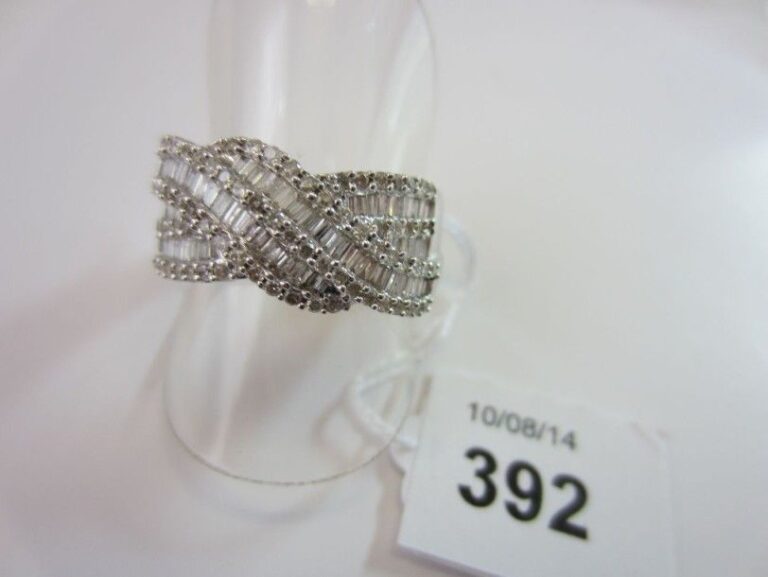 BAGUE bandeau à motifs sinueux, en or gris (750 millièmes) serti de diamants baguettes soulignés de diamants taille brillan