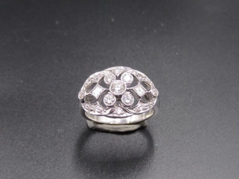BAGUE « bandeau » en or gris (750 millièmes) ajouré, serti de diamants taille brillant et deux diamants calibré