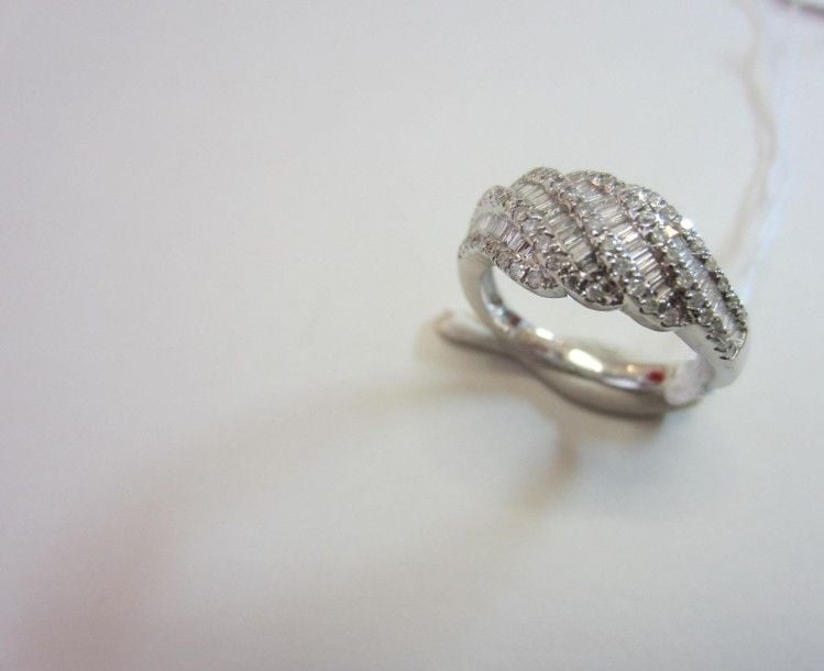 BAGUE bombée en or gris (750 millièmes) serti d'alignements de diamants baguettes soulignés de diamants taille brillan