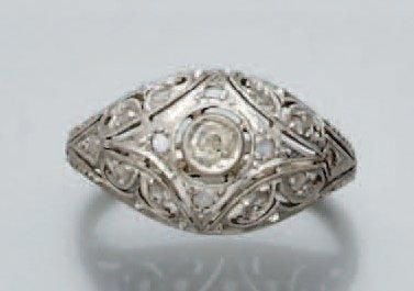 BAGUE bombée en or gris ajouré et ciselé serti d'un diamant taille ancienne entouré de diamants taillés en ros
