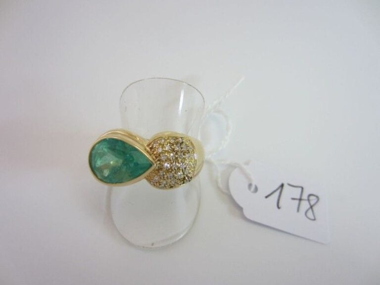 BAGUE bombée en or jaune (750 millièmes) serti d?une émeraude de forme poire épaulée d?un pavage de petits diamant