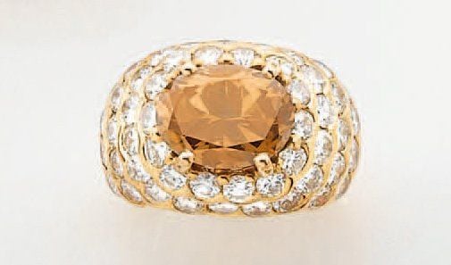 BAGUE « boule » en or jaune serti d'un diamant brun de forme ovale entouré de diamants blanc taille brillan