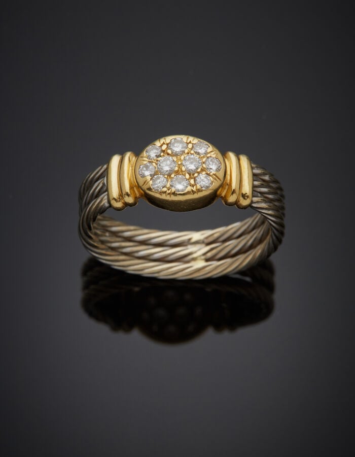BAGUE "câble" en or jaune et or gris (750‰) godronné, le centre pavé de dix dia…