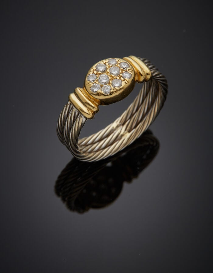 BAGUE "câble" en or jaune et or gris (750‰) godronné, le centre pavé de dix dia…