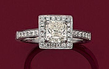 BAGUE carrée en or gris (750 millièmes) serti d'un diamant taille coussin, entouré et épaulé de diamants taille brillan