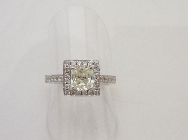 BAGUE carrée en or gris (750 millièmes) serti d’un diamant taille coussin pesant 1,05 carat, entouré et épaulé de diamants taille brillan