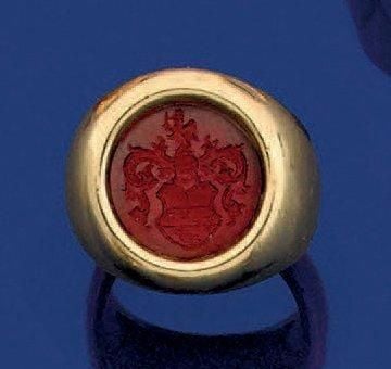 BAGUE chevalière en or jaune (750 millièmes) serti d'une intaille représentant un blason sur cornaline de forme rond