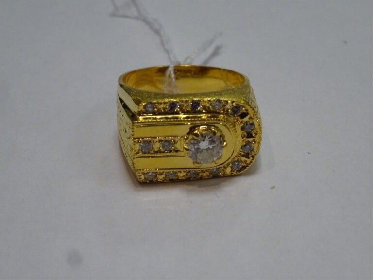 BAGUE chevalière en or jaune guillochée 14K (585 millièmes) ornée d'un diamant central demi-taille en