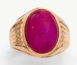 BAGUE chevalière en or jaune partiellement godronné serti d'un important rubis cabochon (fêle, égrisures
