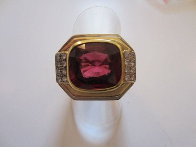 BAGUE chevalière en or jaune serti d'un grenat almandin épaulé de deux alignements de diamants taille brillan