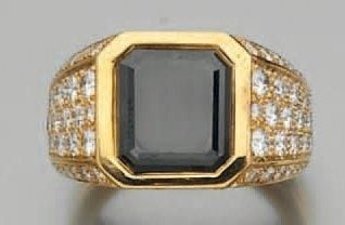 BAGUE chevalière en or jaune surmonté d'un diamant noir taillé à degrés et d'un pavage de diamant
