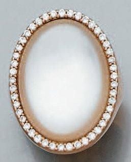 BAGUE chevalière en or rose serti d'une pierre blanche cabochon montée sur nacre de forme ovale, entourée de diamants taille brillan