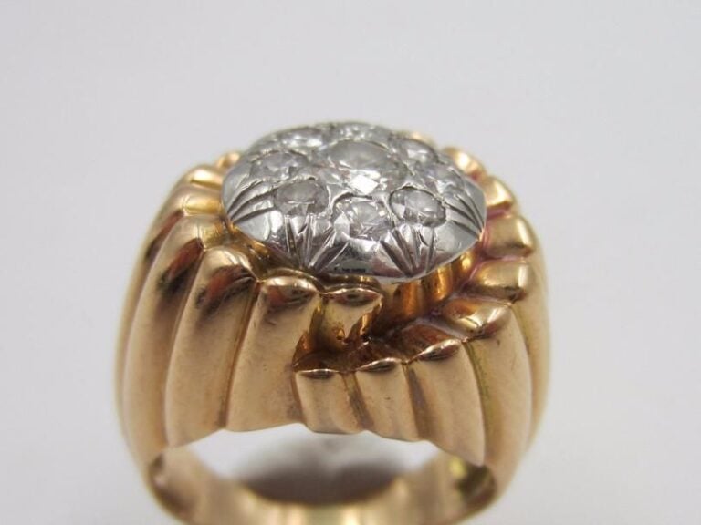 BAGUE chevalière platine (800 millièmes) et or jaune (750 millièmes) godronné et ciselé serti de diamants taille brillant dont un, au centre, plus importan