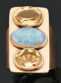 BAGUE chevalière rectangulaire en or jaune serti d'une opale cabochon épaulée de deux topazes de forme oval