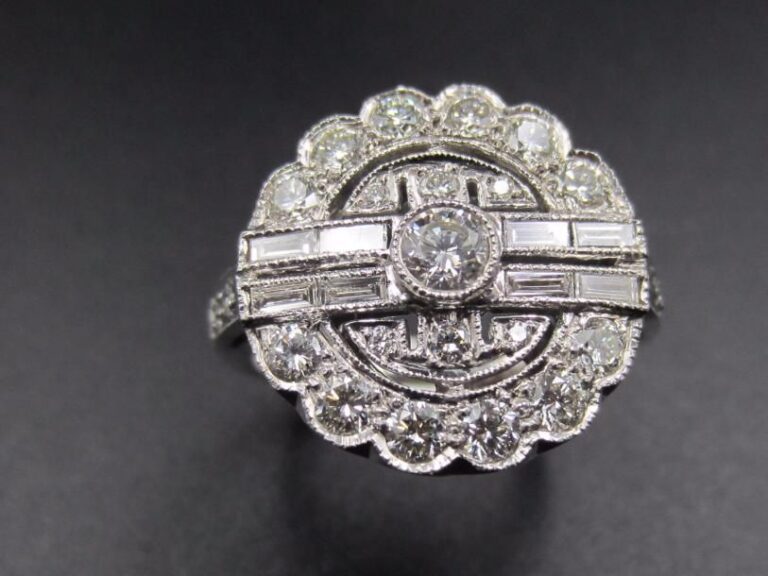 BAGUE « circulaire » en or gris (750 millièmes) ajouré serti de diamants taille brillant dont un, au centre, plus important épaulé de quatre lignes de diamants baguette