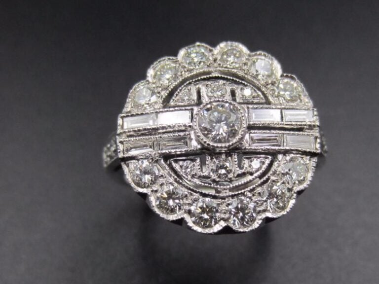 BAGUE « circulaire » en or gris (750 millièmes) ajouré serti de diamants taille brillant dont un, au centre, plus important épaulé de quatre lignes de diamants baguette
