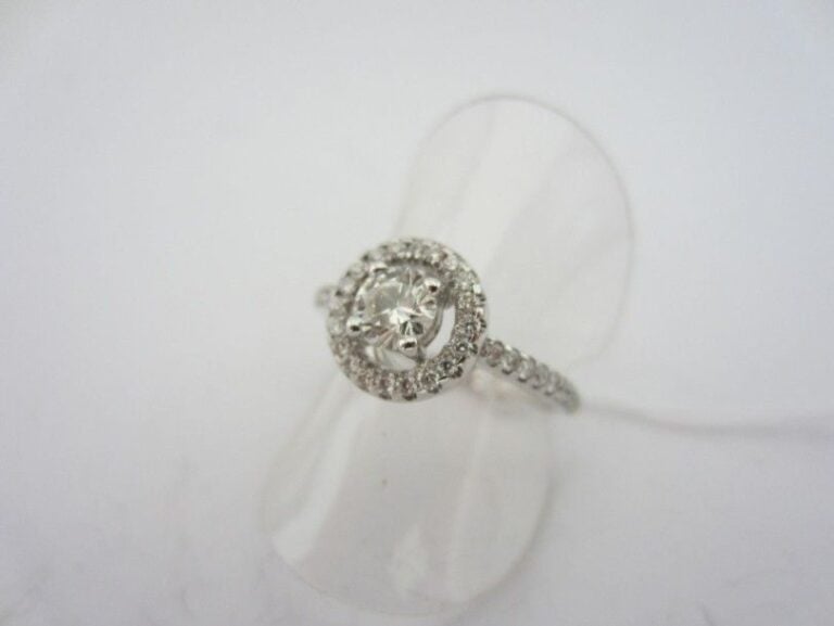 BAGUE circulaire en or gris (750 millièmes) ajouré serti de diamants taille brillant dont un au centre plus importan