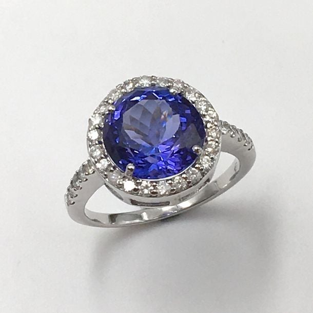 BAGUE circulaire en or gris (750 millièmes) serti d'une tanzanite de forme ronde pesant environ 5,7 carats, entourée de diamants taille brillan