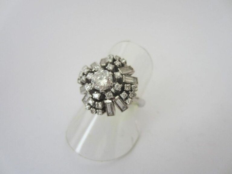 BAGUE circulaire en or gris (750 millièmes) serti de diamants taille brillant, 8/8 et baguettes, dont un au centre plus importan