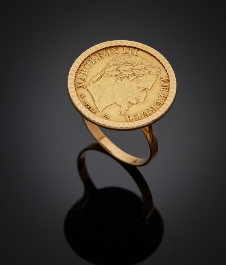 BAGUE circulaire en or jaune (750‰) guilloché, serti d'une pièce de 10FF (1864)…