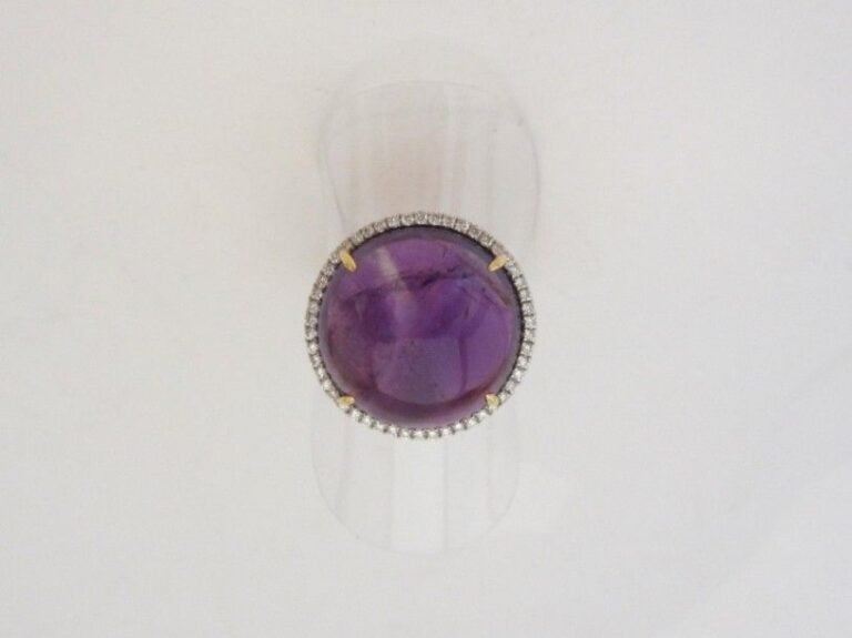 BAGUE circulaire en or jaune et or gris (750 millièmes) serti d’une améthyste cabochon entourée de diamants taille brillan