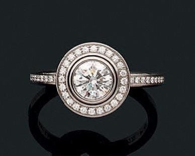 BAGUE circulaire en platine (900 millièmes) serti d'un diamant taille brillant pesant 0,61 carat, entouré de petits diamant