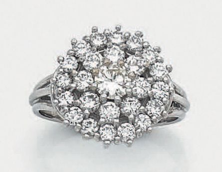 BAGUE «cocktail» circulaire en or gris (750 millièmes) serti de diamants taille brillant dont un, au centre, plus importan
