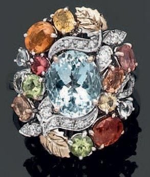 BAGUE «cocktail» en or gris 14 carats (585 millièmes) serti d'une aiguemarine de forme ovale entourée de pierres précieuses de couleur et de diamants taille brillan