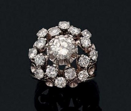 BAGUE «cocktail» en or gris (750 millièmes) ajouré serti de diamants ronds dont un, au centre, plus importan