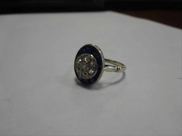 BAGUE en or blanc 18K (750°/00) sertie de diamants taille brillant au centre entouré de saphirs synthétiques calibré