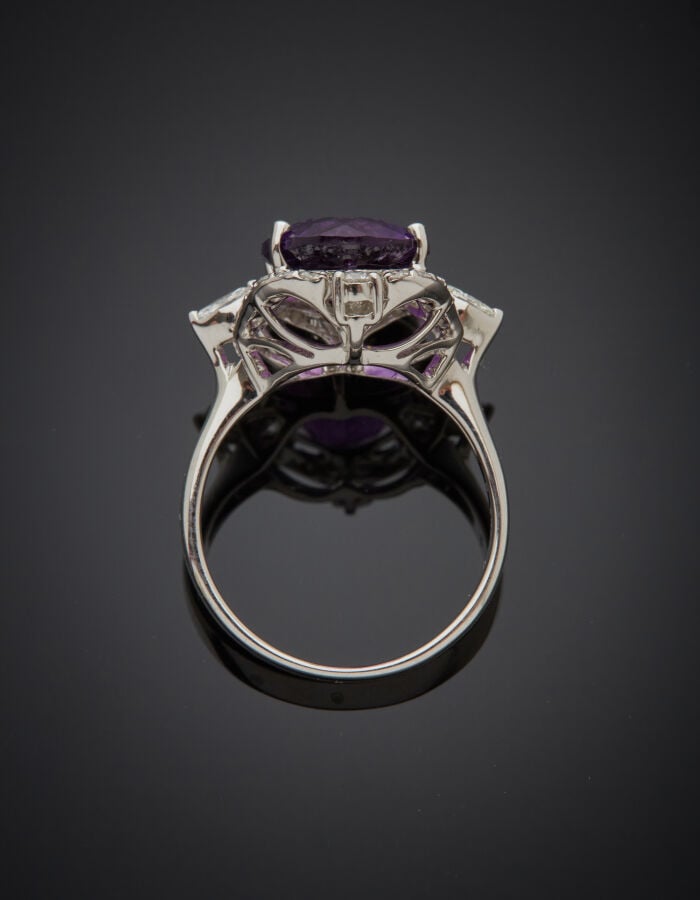 BAGUE en or gris (750‰) ajouré, à motifs stylisés, serti d'une améthyste de for…