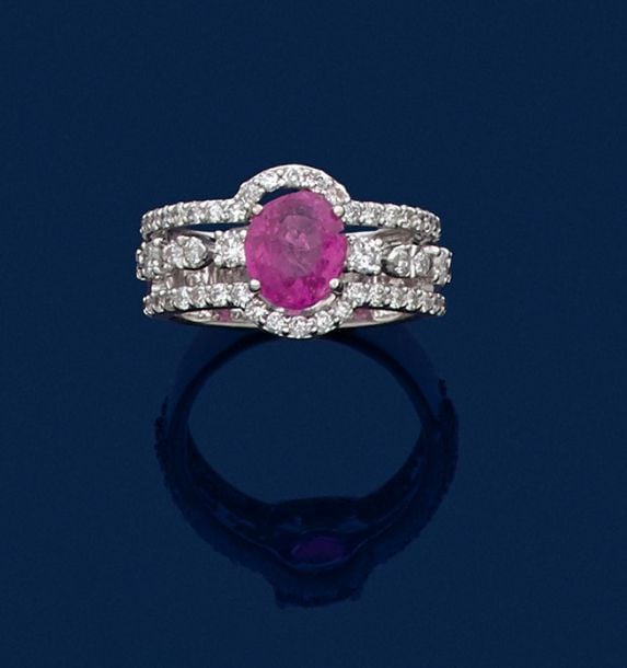 •BAGUE en or gris (750‰) ajouré centré d'un saphir rose ovale pesant 2 carats en