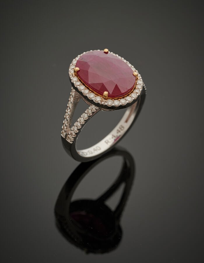 BAGUE en or gris (750‰) ajouré, serti d'un rubis ovale pesant 4,48 carats, ento…