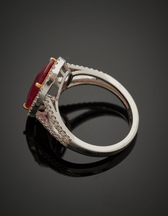 BAGUE en or gris (750‰) ajouré, serti d'un rubis ovale pesant 4,48 carats, ento…