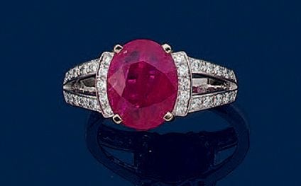 BAGUE en or gris (750 millièmes) ajouré, serti d'un rubis de forme ovale épaulé de lignes de petits diamants taille brillan