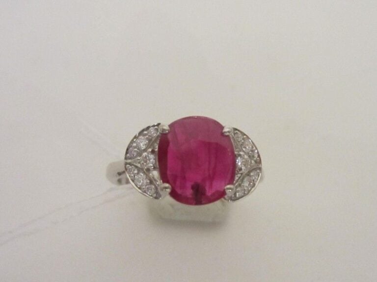 BAGUE en or gris (750 millièmes) ajouré serti d’un rubis de forme coussin pesant 1,72 carat, épaulé de petits diamants taille brillan