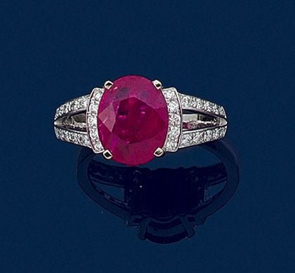 BAGUE en or gris (750 millièmes) ajouré, serti d’un rubis de forme ovale épaulé de lignes de petits diamants taille brillan