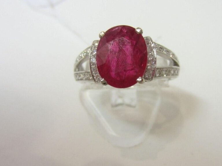 BAGUE en or gris (750 millièmes) ajouré serti d’un rubis de forme ovale épaulé de lignes de petits diamants taille brillan