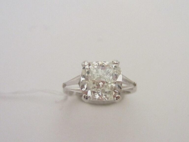 BAGUE en or gris (750 millièmes) serti d'un diamant coussin pesant 4,03 carats, épaulé de deux diamants taeper