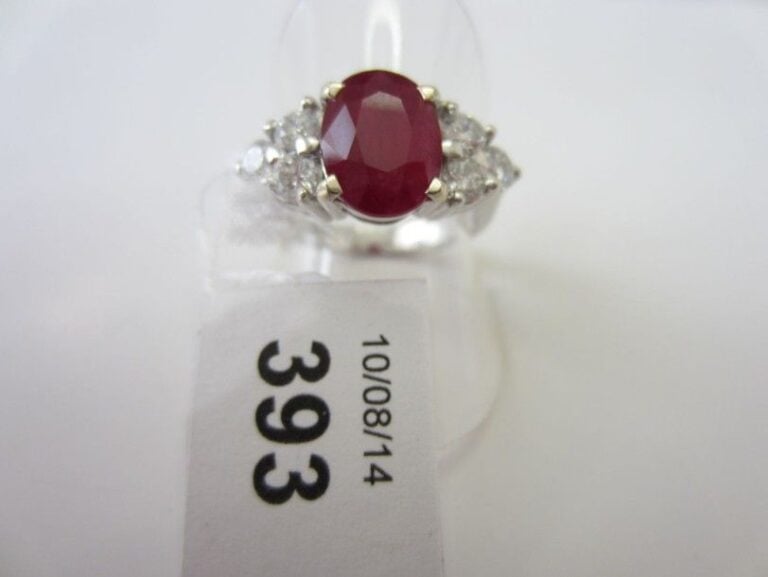 BAGUE en or gris (750 millièmes) serti d'un rubis ovale épaulé de six diamants taille brillan