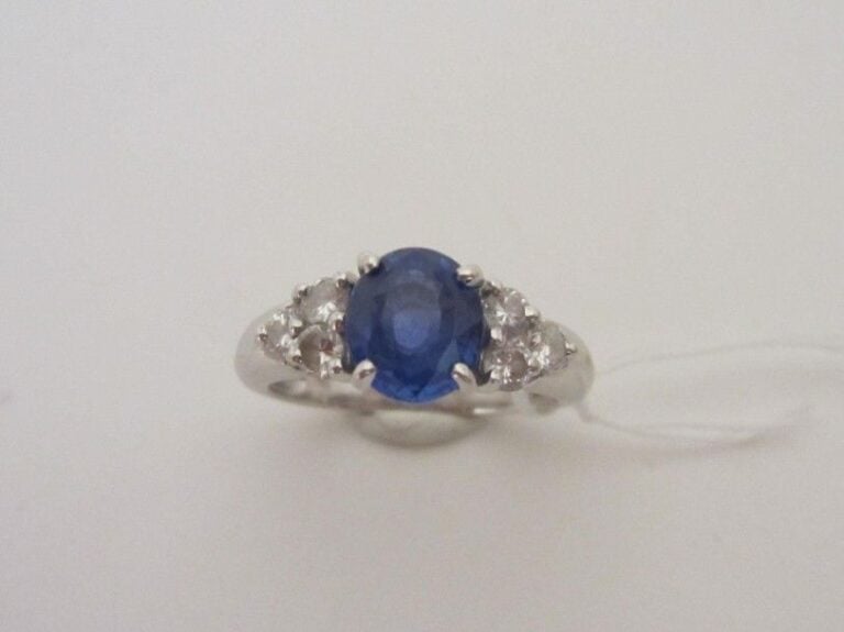 BAGUE en or gris (750 millièmes) serti d'un saphir de forme ovale épaulé de trois diamants taille ancienne de chaque côt