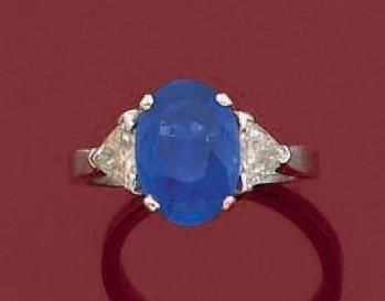 BAGUE en or gris (750 millièmes) serti d'un saphir pesant 2,61 carats épaulé de diamants troïda