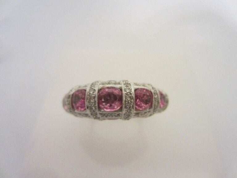 BAGUE en or gris (750 millièmes) serti de saphirs roses de forme ovale alternées de lignes de diamants taille brillan