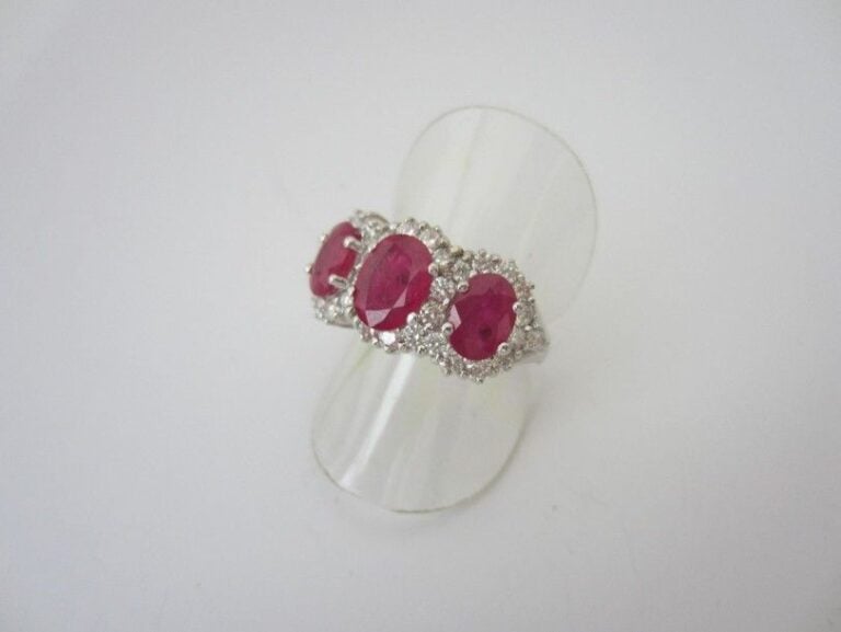 BAGUE en or gris (750 millièmes) serti de trois rubis de forme ovale entouré de diamants blanc taille brillan