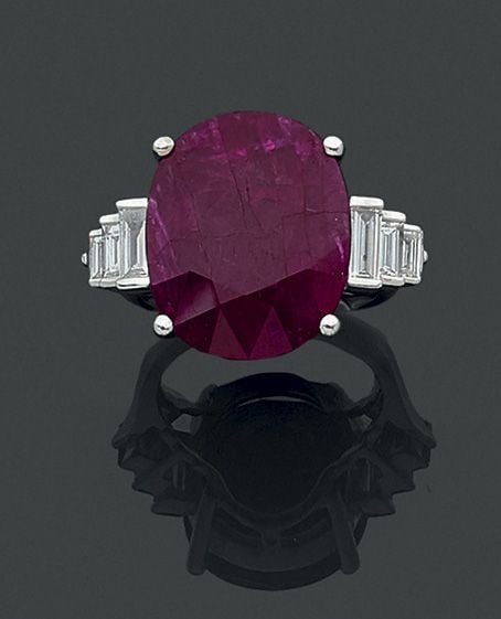 BAGUE en or gris (750 millièmes) serti d’un important rubis pesant 18,27 carats épaulé de six diamants baguettes en chut