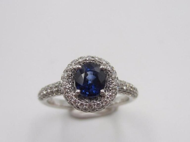 BAGUE en or gris (750 millièmes) serti d’un saphir de forme ovale pesant 0,59 carat et de pavages de diamants taille brillan